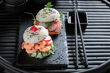 Unique sush burger with rice and seafood as Japanese appetizers.
