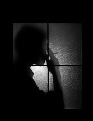 Silhouette of a man smoking near the window. Smoking at night. 