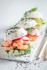 Exquisite sush burger with rice and seafood as Japanese appetizers.