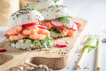 Unique sush burger with fish and shrimps sprinkled with sesame.
