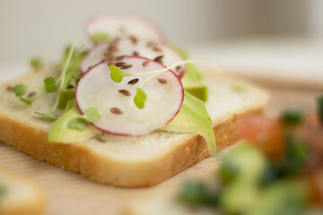 sandwich with avocado and radish slices, around which parsley