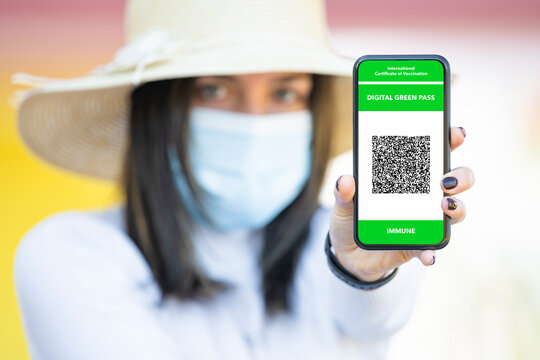 Defocused young girl holding a smartphone with a Digital Green Pass. The Digital Green Certificate facilitate the safe free movement of citizens within the EU during the COVID-19 pandemic.
