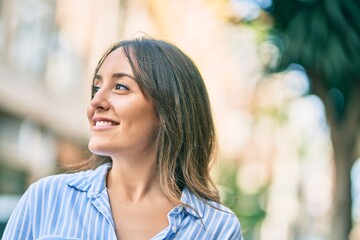 Fototapeta premium Young hispanic woman smiling happy standing at the city.