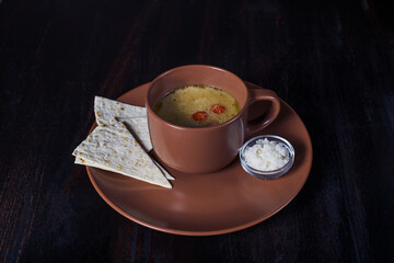 creamy soup with pita bread in a plate, beautiful serving, dark background