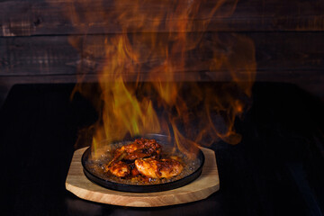 fajitos, meat in a frying pan with fire on a wooden tray, beautiful serving, dark background