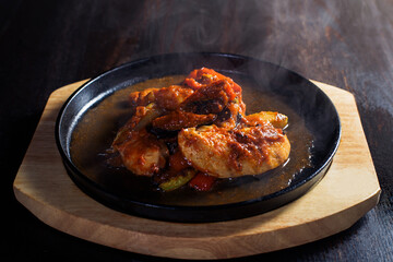 fajitos, meat in a frying pan with fire on a wooden tray, beautiful serving, dark background