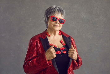 Headshot portrait of fashionable grey-haired senior woman posing alone wearing sunglasses, trendy...