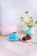 spring composition cherry flowers coffee cup cosmetic bag and biscuits with chocolate vertical