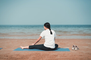 Woman doing yoga on the beach