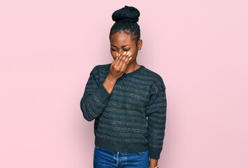 Young african american woman wearing casual clothes smelling something stinky and disgusting, intolerable smell, holding breath with fingers on nose. bad smell