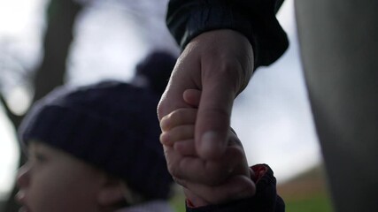 Mother holding baby toddler hand, parent waiting to cross street. Child holds mom hand close-up - Powered by Adobe