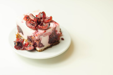 Japanese cheesecake with cherry sauce and fresh cherries on the ceramic plate and red background