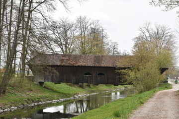 Old wooden Grubenmann Bridge crossing the River Glatt, Canton of Zurich, Switzerland near tourist road around zurich airport. surrounded by trees and bushes during spring season.