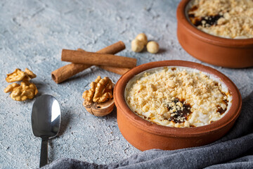 Baked rice pudding turkish milky dessert sutlac in earthenware casserole with hazelnuts