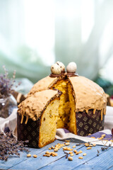 Home Made Panettone. Traditional Italian sweet bread. Panettone with a slice served on a wooden table.