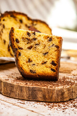 Home Made Panettone. Traditional Italian sweet bread. Panettone with a slice served on a wooden table.