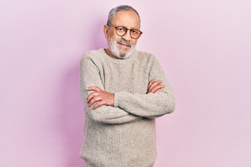 Handsome senior man with beard wearing casual sweater and glasses happy face smiling with crossed...