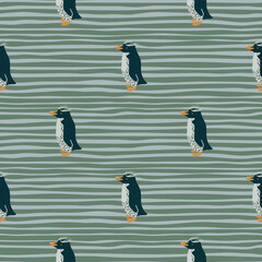 Creative crested penguins shapes seamless pattern. Hand drawn arctic print. Green and blue striped background.