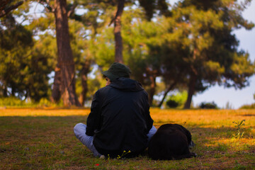 person sitting with dog in autumn park