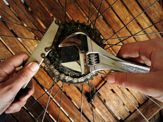 Hand of a craftsman manipulating a bicycle wheel for mending, maintenance and repair of a mountain...