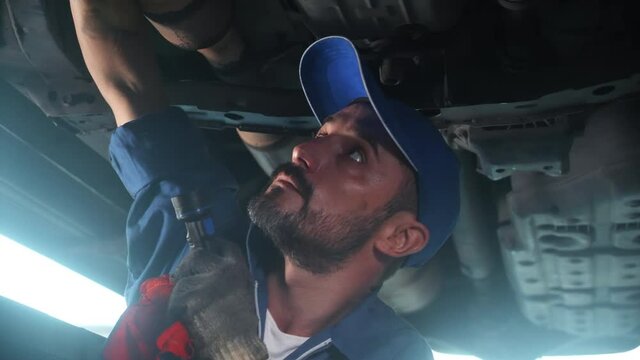 Young man is mechanic repair car in the garage with professional, auto service, maintenance and technician, automobile examining and fix, one person, male diagnostics  and inspection automotive.