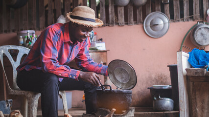 Native African man happily cook in the kitchen.16:9 style
