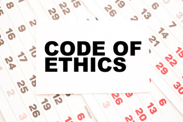 Notepad with text CODE OF ETHICS on the office desk with stationery. A blank notepad for entering a copy or text. business