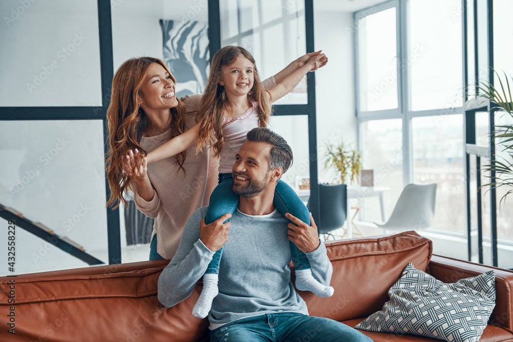 Wall mural Happy young family smiling and embracing