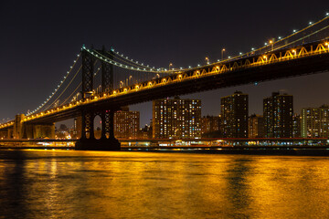 Fototapeta na wymiar Manhattan Bridge from Brooklyn to Manhattan at night, before Lower East Side waterfront, New York, USA.