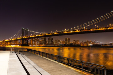 Fototapeta premium Manhattan Bridge from Brooklyn to Manhattan at night, with a viewing platform on Brooklyn side.