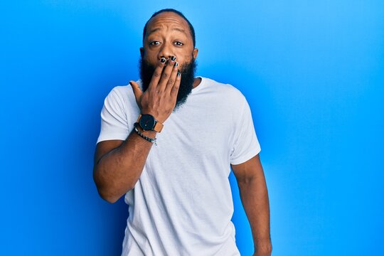 Young african american man wearing casual white tshirt bored yawning tired covering mouth with hand. restless and sleepiness.