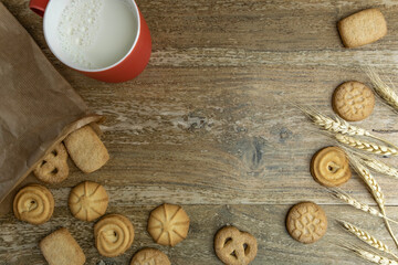 Wheat cookies, milk cup, wheat ears for Jewish holiday Shavuot on rustic background with copy space. 