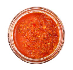 Spicy chili pepper sauce in galss jar, dip made from milled paprika with extra virgin olive oil, isolated on white background, top view