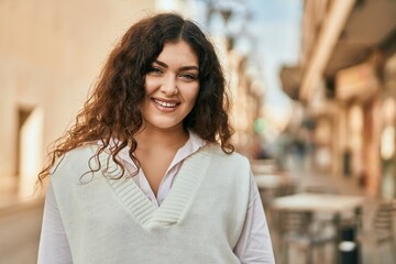 Young hispanic woman smiling happy standing at the city.