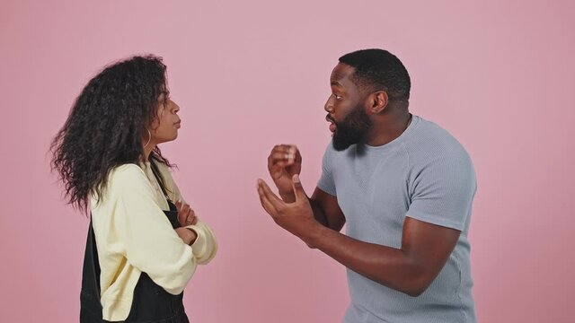 Relationship problems. Emotional african american man and woman arguing, shouting at each other over purple background