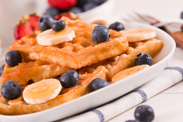 Waffles with blueberries, bananas and honey.