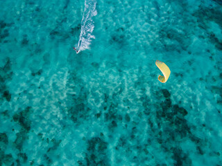 Kite surfer on turquoise tropical clear water aerial drone shot