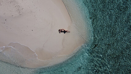 Mature lady on vacation laying on a tropical beach