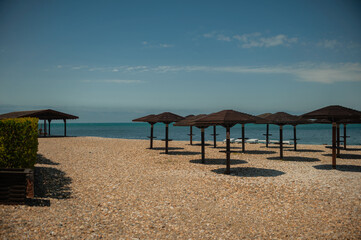 Wooden beach umbrellas by the sea in clear weather