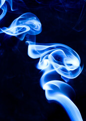 Bright blue, luminescent smoke with a white tinge forms a vortex like a hurricane.