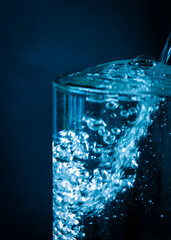 Super blue water rains in a glass container or glass, with blue water, bubbles.