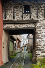 Fototapeta na wymiar ruelle médiévale traversant un porche de bois