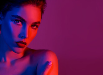 Beautiful young woman with clean perfect skin in colored neon lights. 