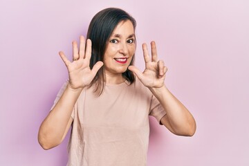 Middle age hispanic woman wearing casual clothes showing and pointing up with fingers number eight while smiling confident and happy.