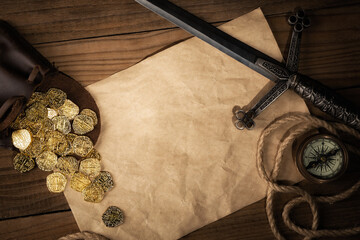 Ancient weapon on brown wooden table background with copy space. Gold coins, compass and dagger. Pirate concept. - 432566489