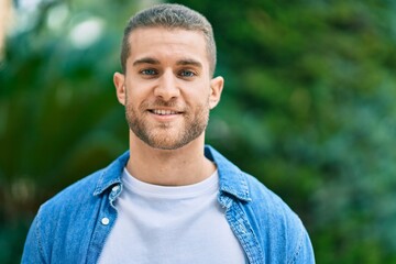 Young caucasian man smiling happy standing at the park.