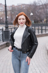 Portrait of a beautiful and positive redhead woman with clothes in grunge style. Posing while walking