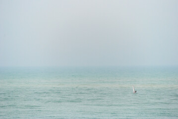 Tiny Optimist dinghy alone on wide ocean