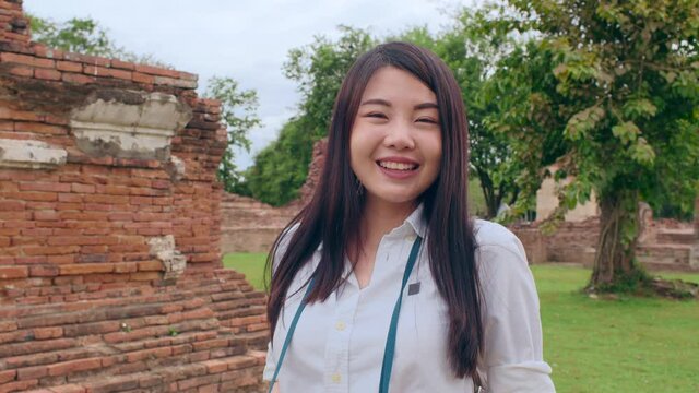 Cheerful beautiful young Asian backpacker blogger woman casual with camera take photo smiling traveling around pagoda at the old city, Lifestyle backpack tourist travel holiday concept. Point of view.
