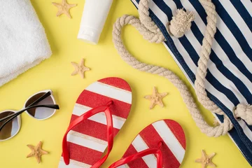 Foto op Plexiglas Top view photo of white towel cream bottle beach bag striped flip-flops sunglasses and starfishes on isolated pastel yellow background © ActionGP